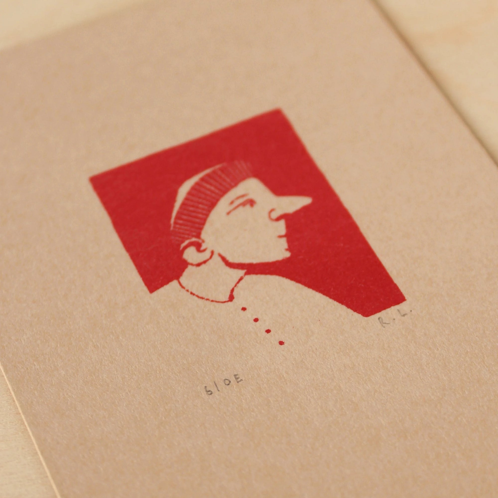 Red illustration of a profiled figure wearing a hat on beige paper