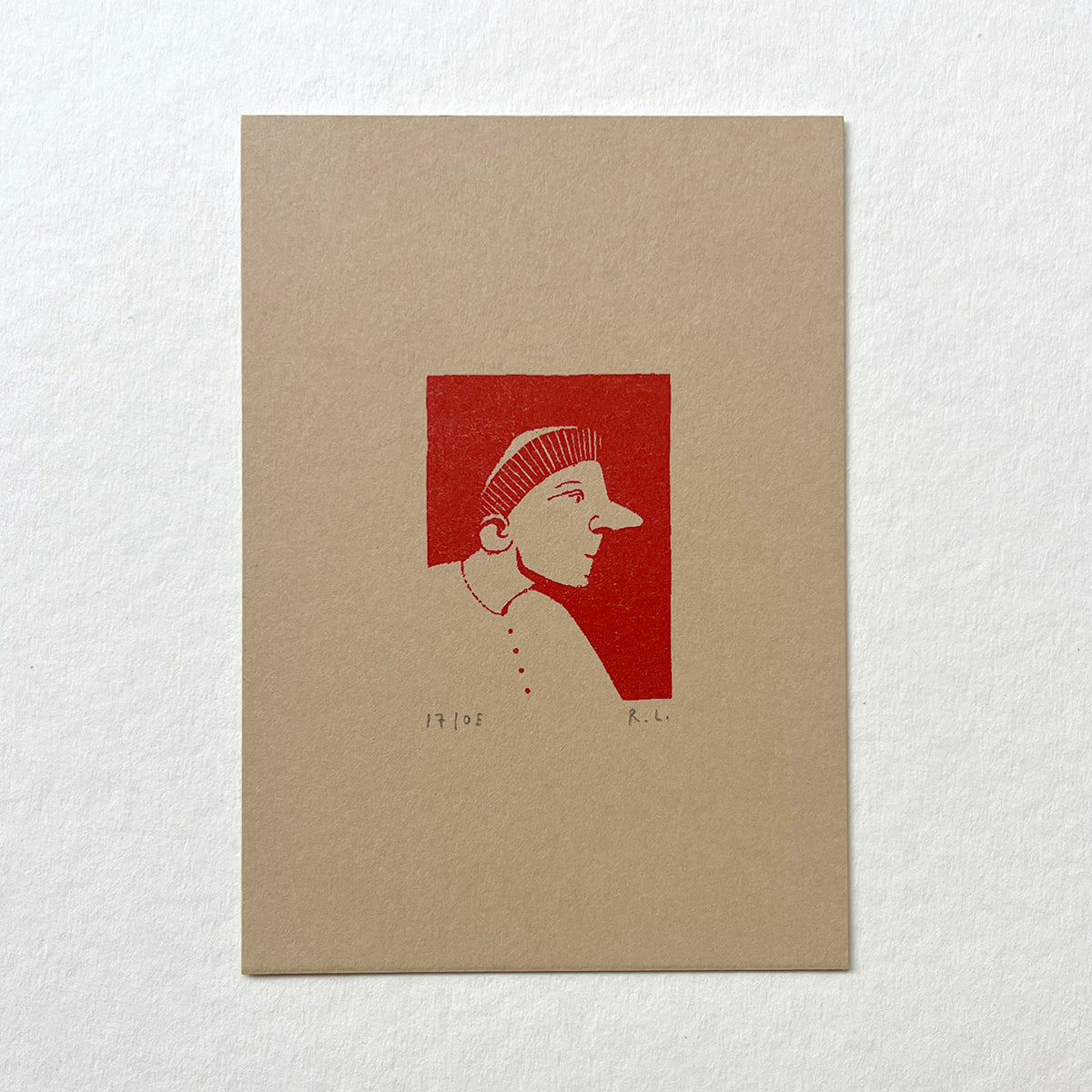 Art print of a stylized profile on beige paper with red background
