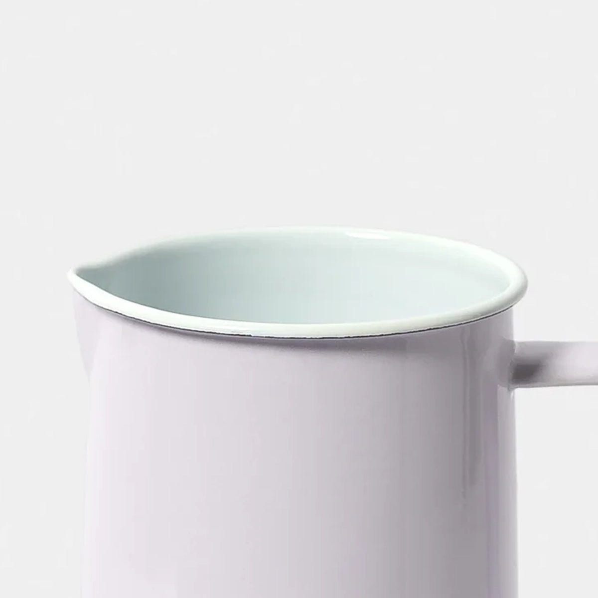 Pale lilac enamel falconware jug on a white background 