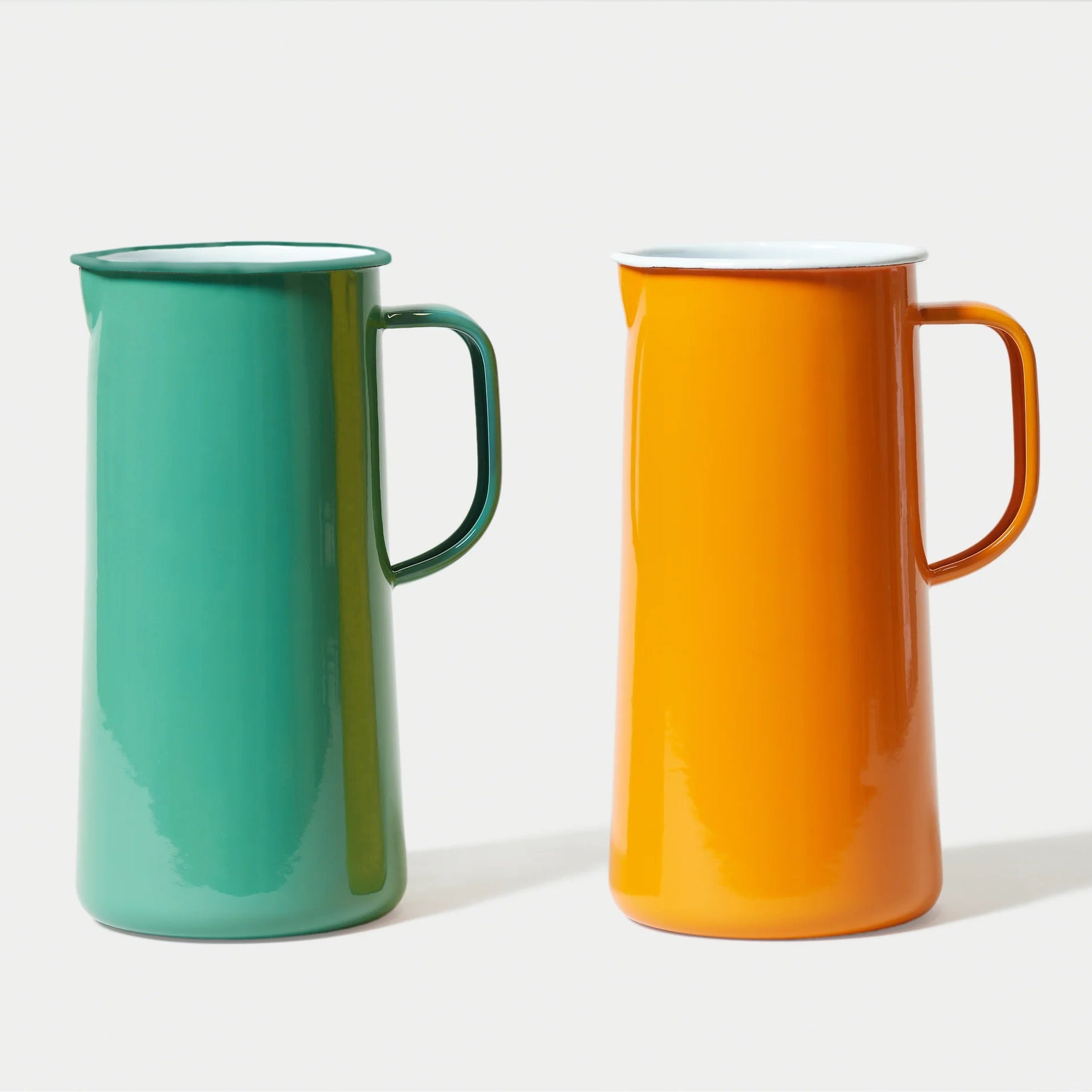An Orange tangerine and a Spring Green Teal falconware enamel jug  a white background