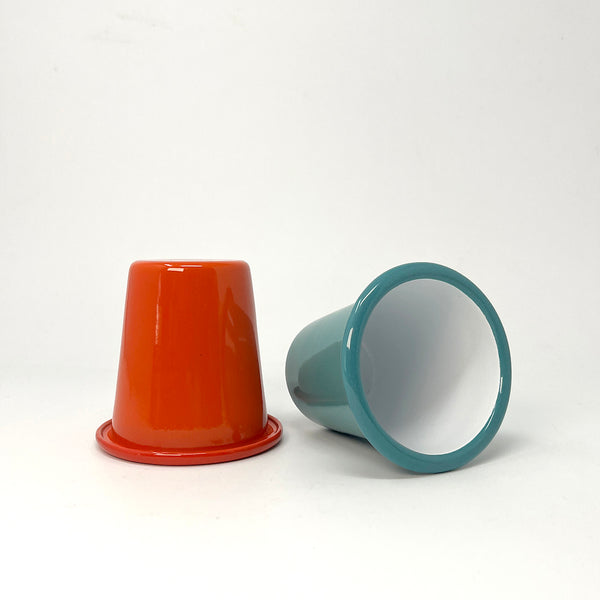 Red and teal enamel tumbler on a white background