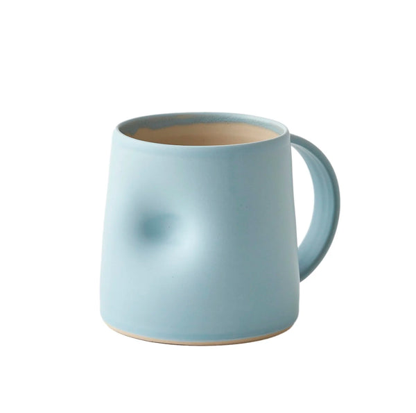Light blue Emma Lacey hand thrown mug, with a thumb dimple on a white background