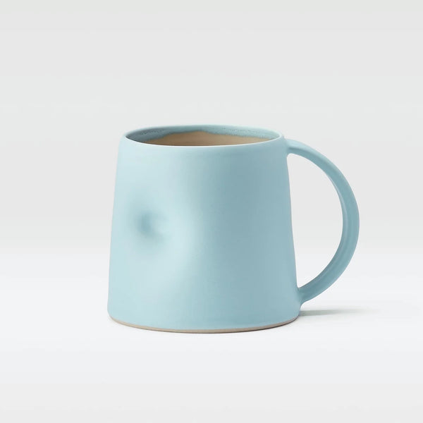 Light blue Emma Lacey hand thrown mug, with a thumb dimple on a white background