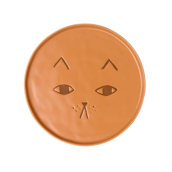 A round terracotta-colored ceramic plate featuring a carved cat face design, shown against a plain white background.