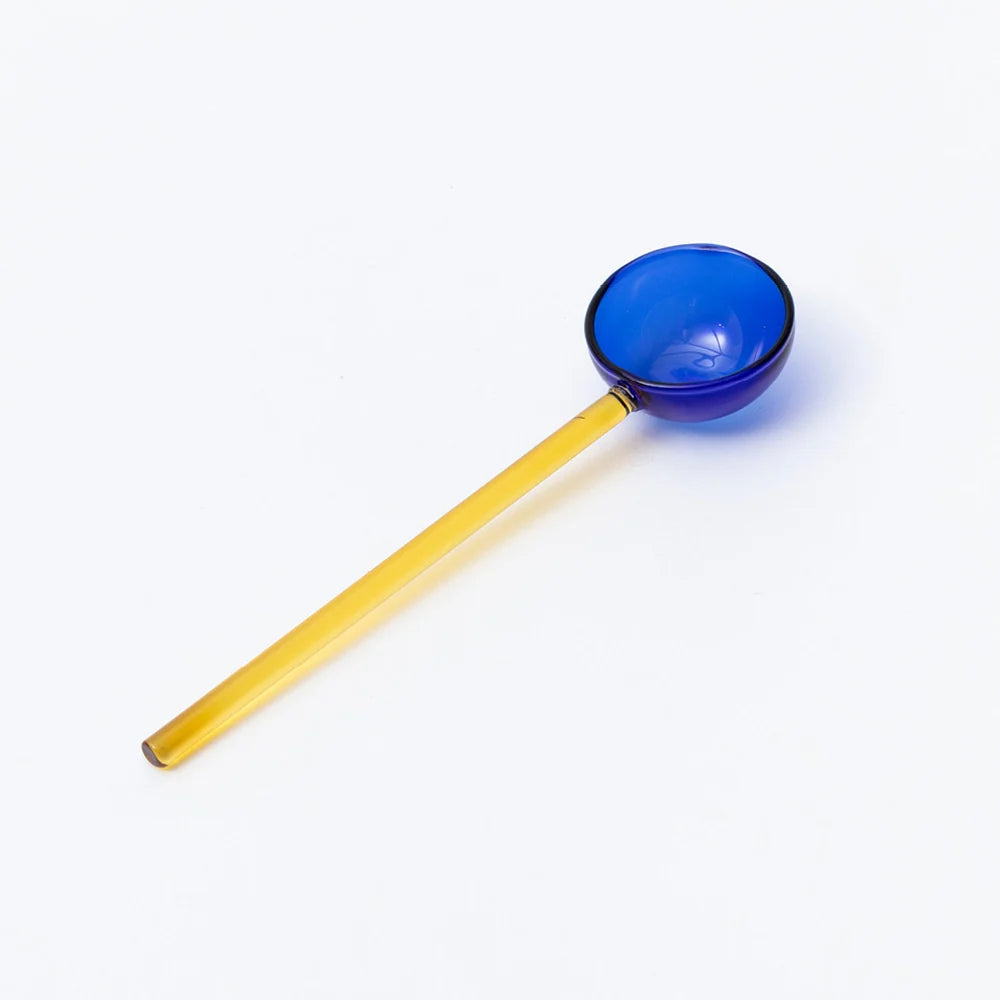Yellow handled spoon with a blue scoop on a white background