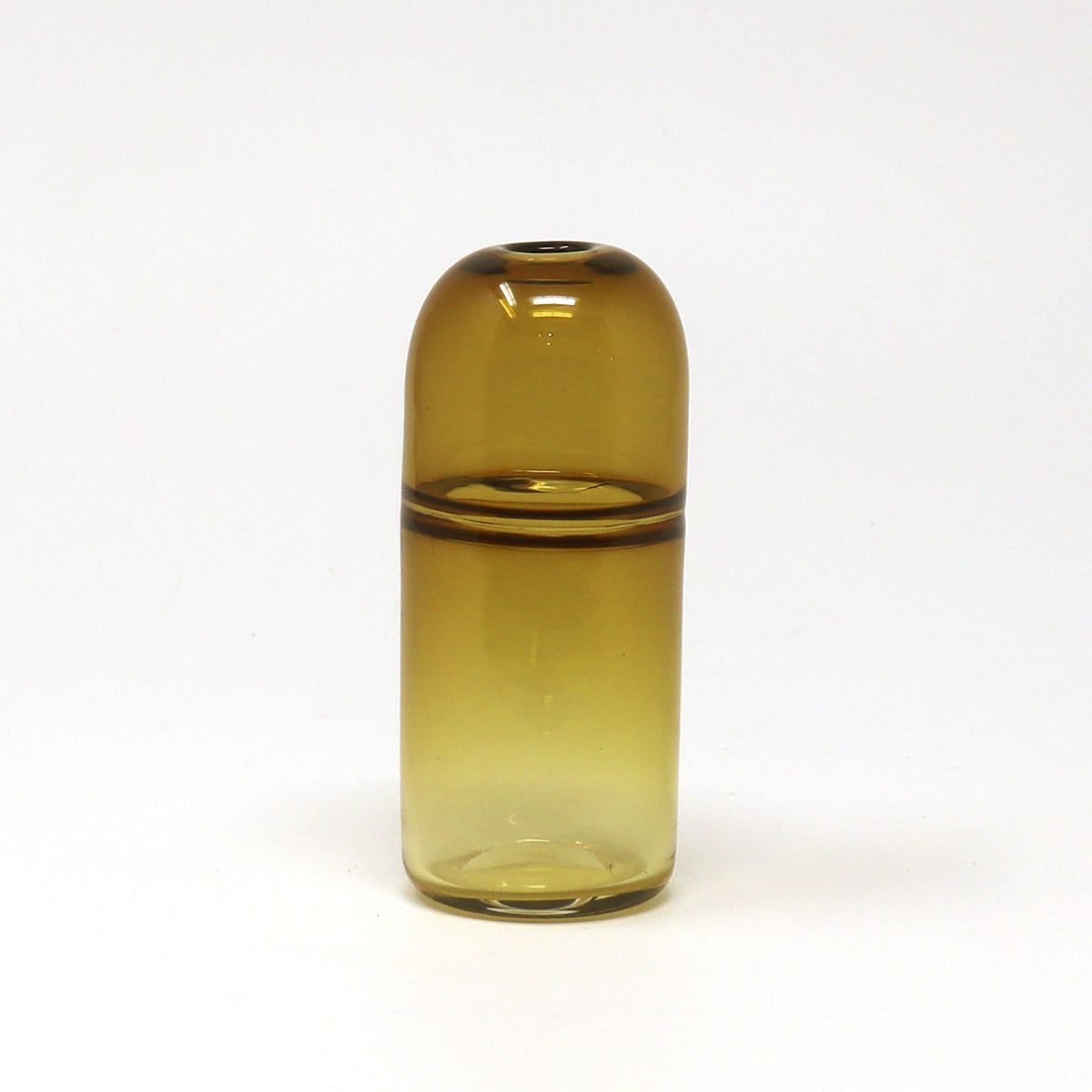 Tall slim amber bud vase on a white background by Emma Baker
