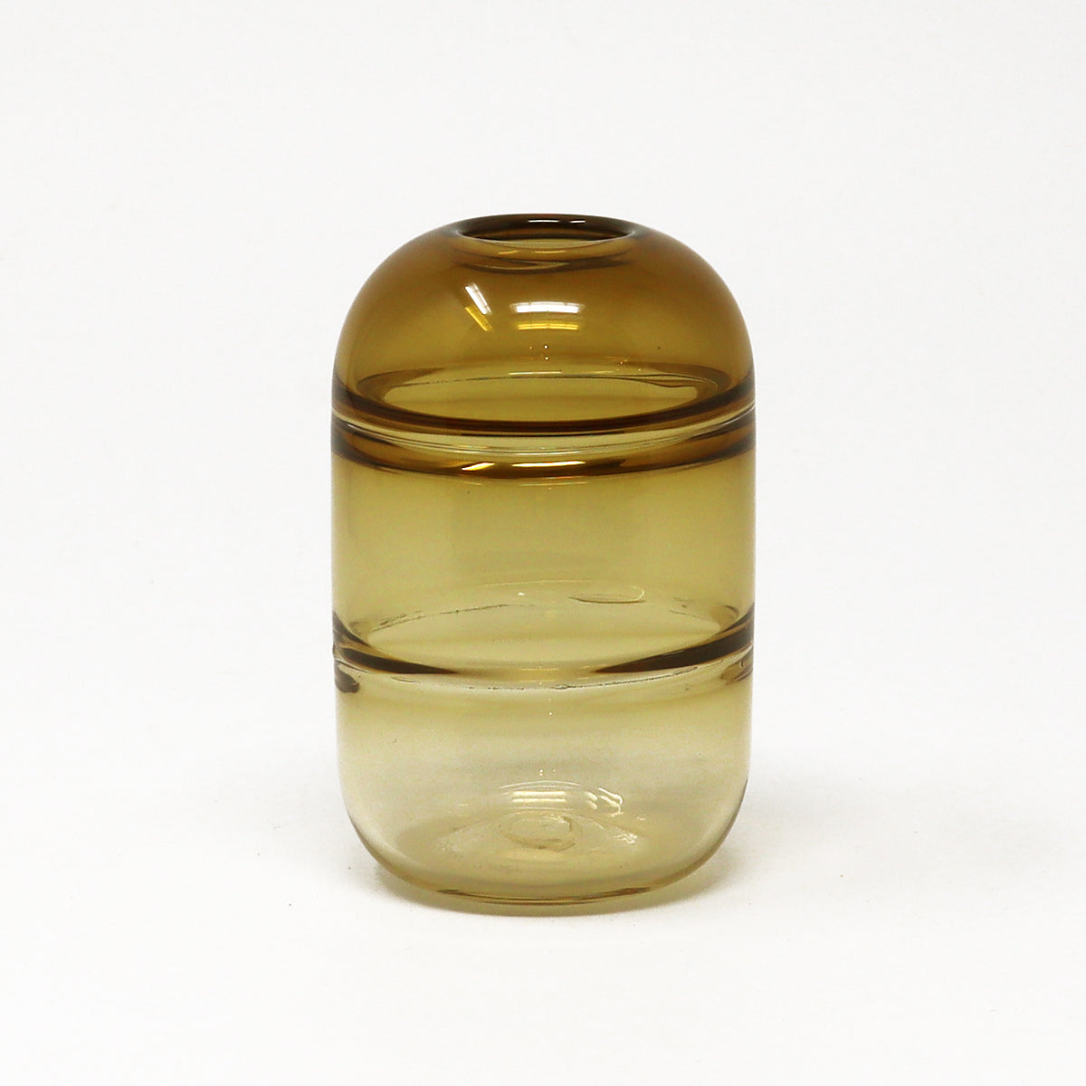 Amber glass bud vase with a brownish tint on a white background