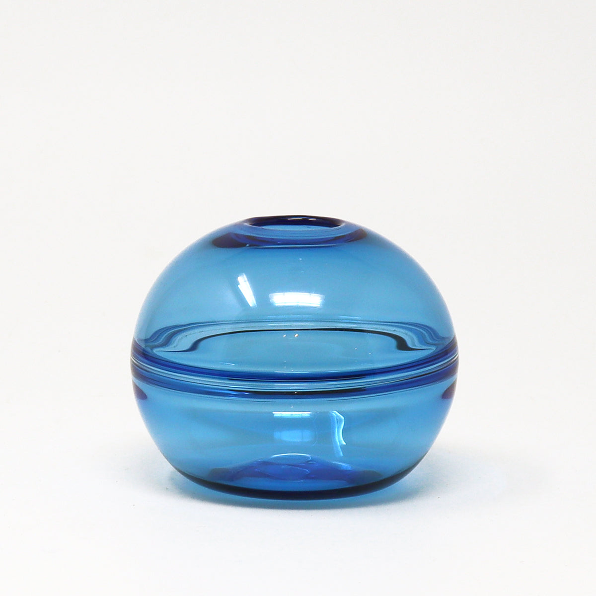Blue glass vase on a white background by Emma Baker