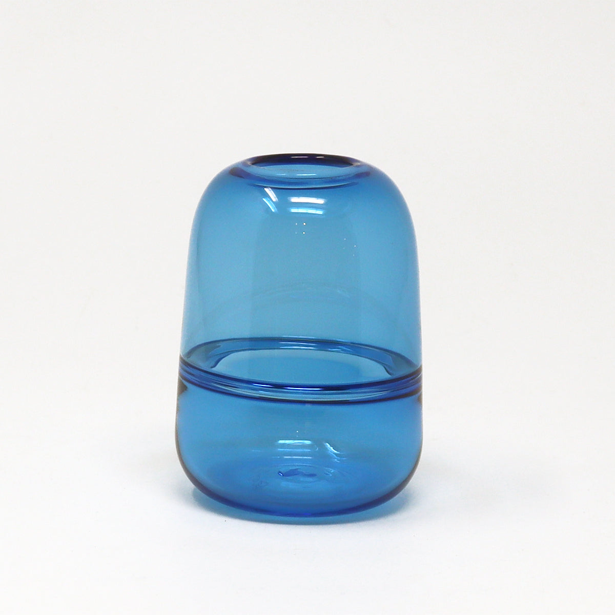 Blue glass hand blown bud vase by Emma Baker on a white background