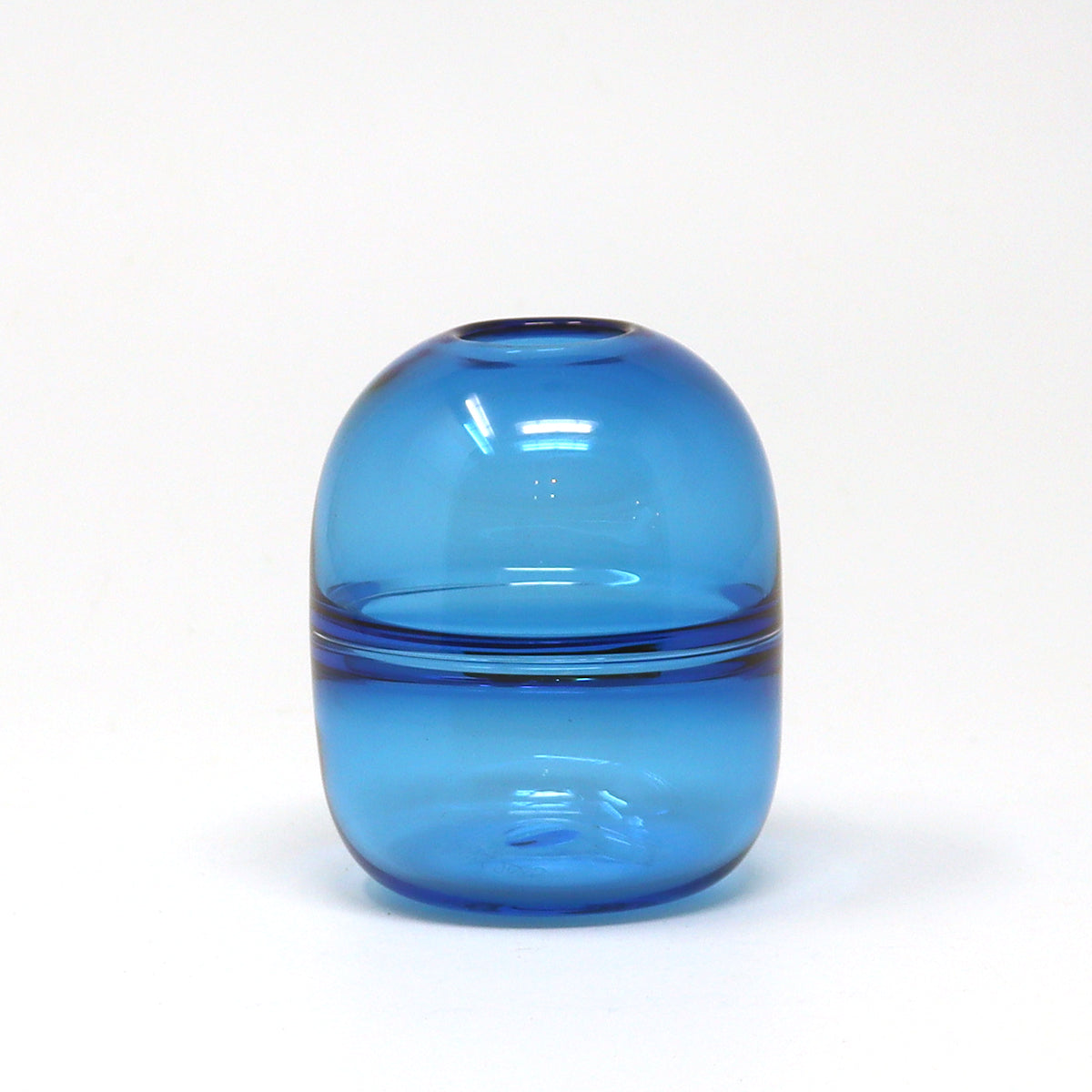 Blue hand blown glass bud vase on a white background