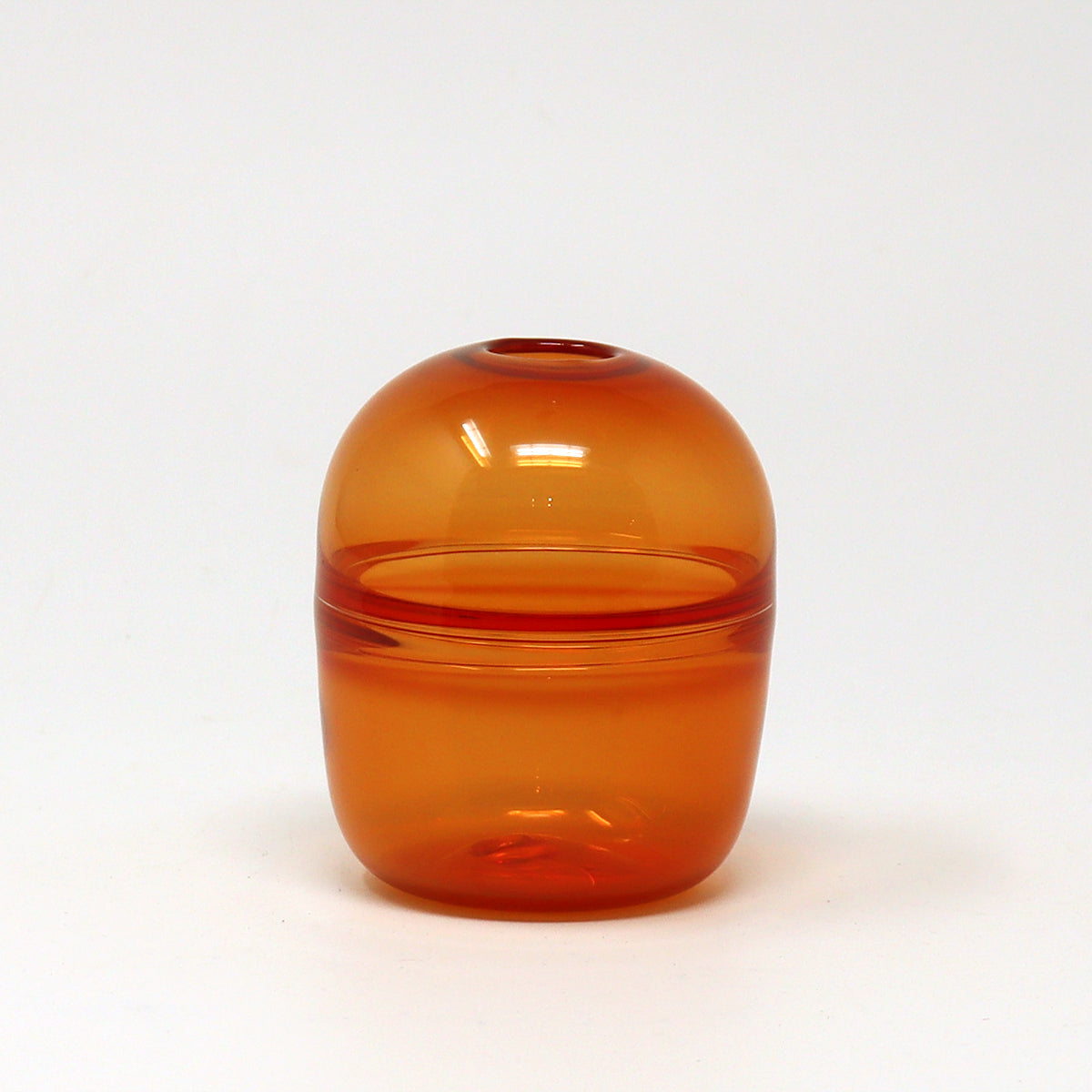 Amber glass bud vase on a white background Emma Baker
