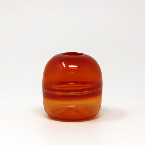 Red orange glass bud vase on a white background
