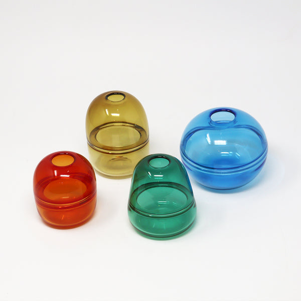 Four colourful hand blown glass bud vases on a white background Emma Baker