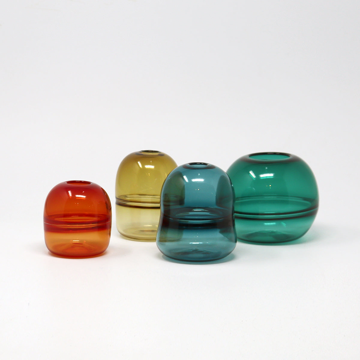 Four colourful hand blown glass vases on a white background Emma Baker