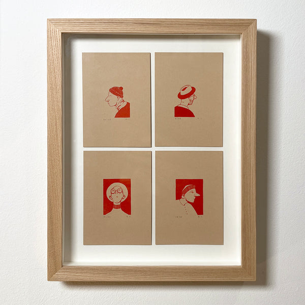 Framed artwork with four red portraits of people wearing different hats on beige paper against a white background