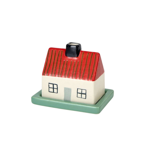 A small decorative house-shaped container or figurine with a red striped roof, cream-colored body, black window and chimney details, and a mint green base, shown on a plain white background.