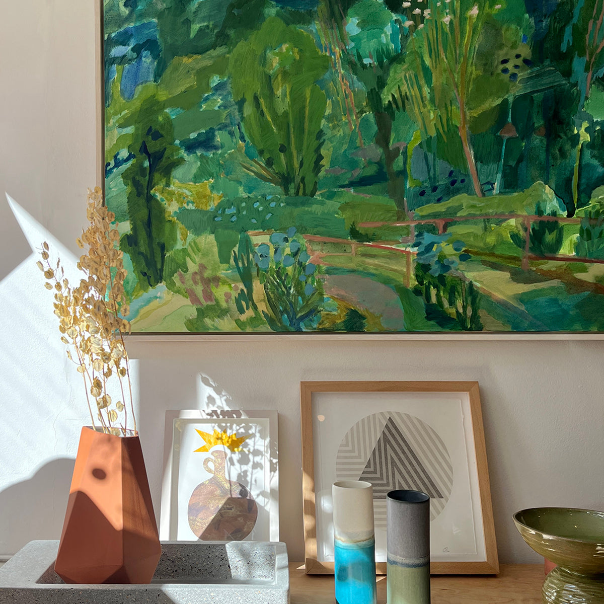Close up of a Colourful landscape painting in greens with trees and a pathway painting of Costa Rica. Acrylic on canvas, framed in a white wash tray frame by Ginny Elston