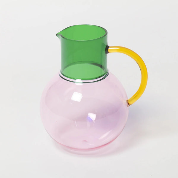 Glass carafe with green top and yellow handle on a white background
