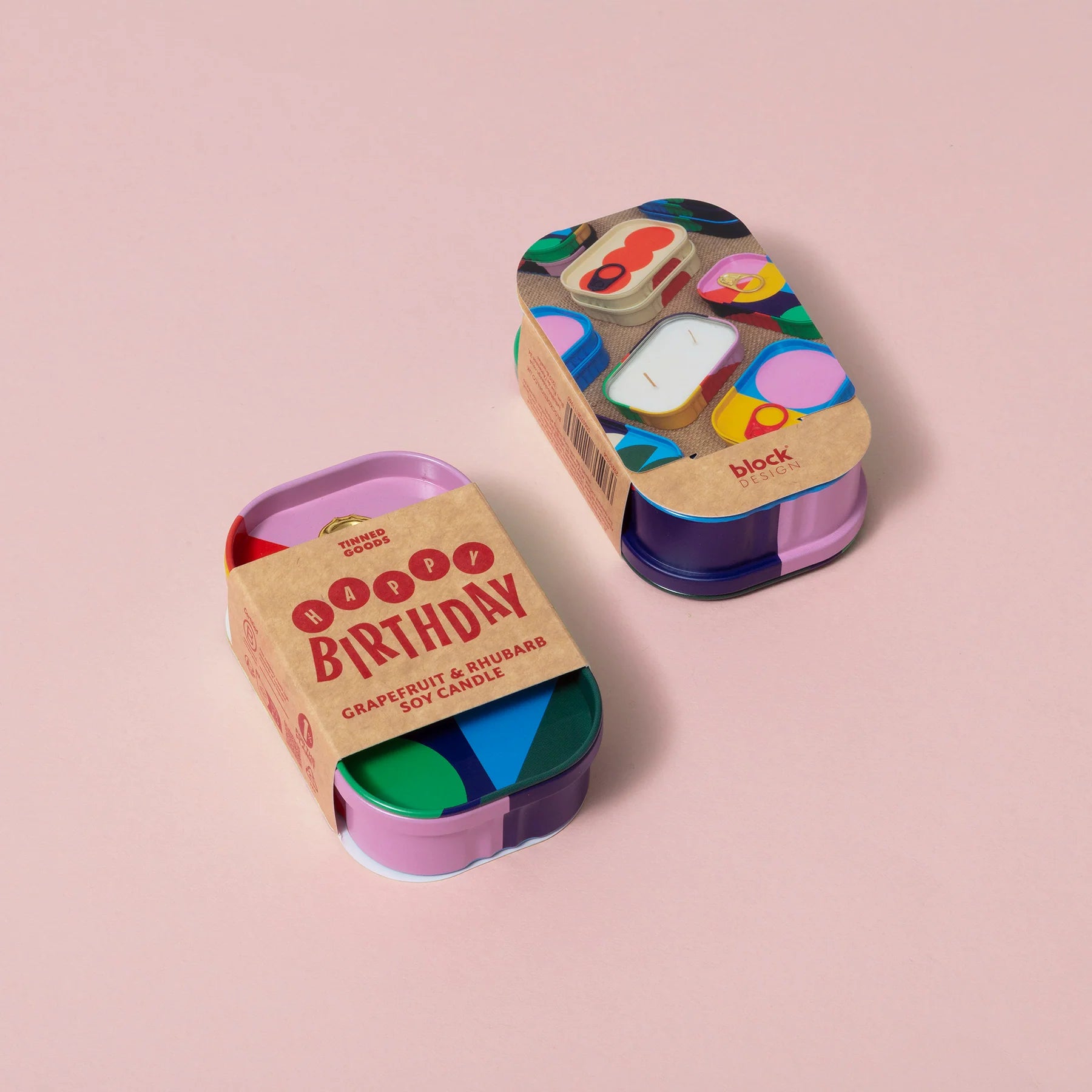 Two colorful candle tins with 'Happy Birthday' text on a white background